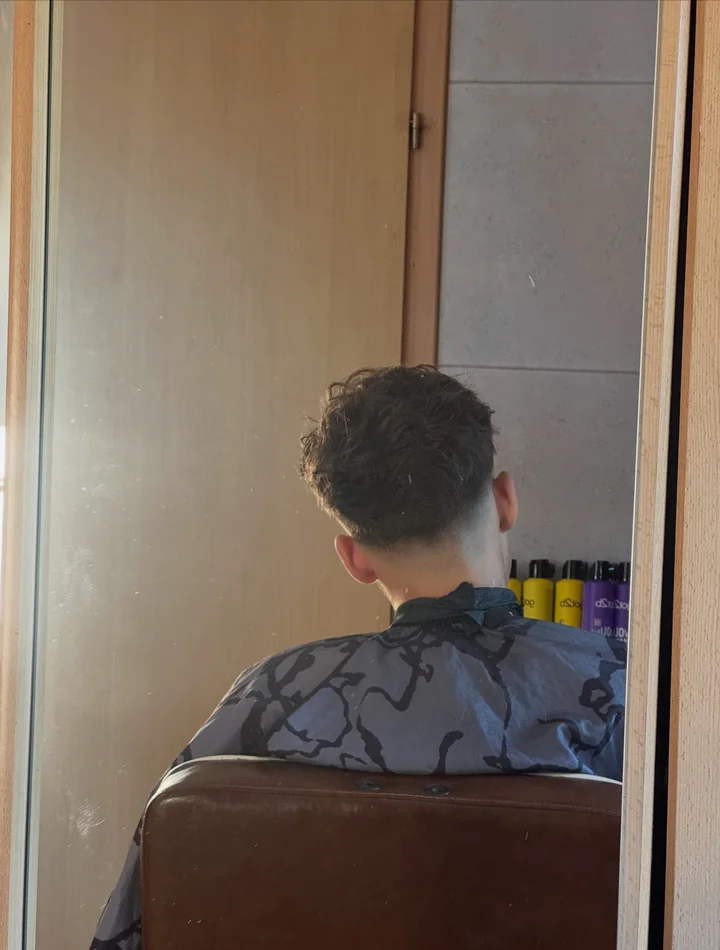 Męskie strzyżenie typu crop z teksturowaną grzywką i burst fade przy skroniach – Dominos Barber